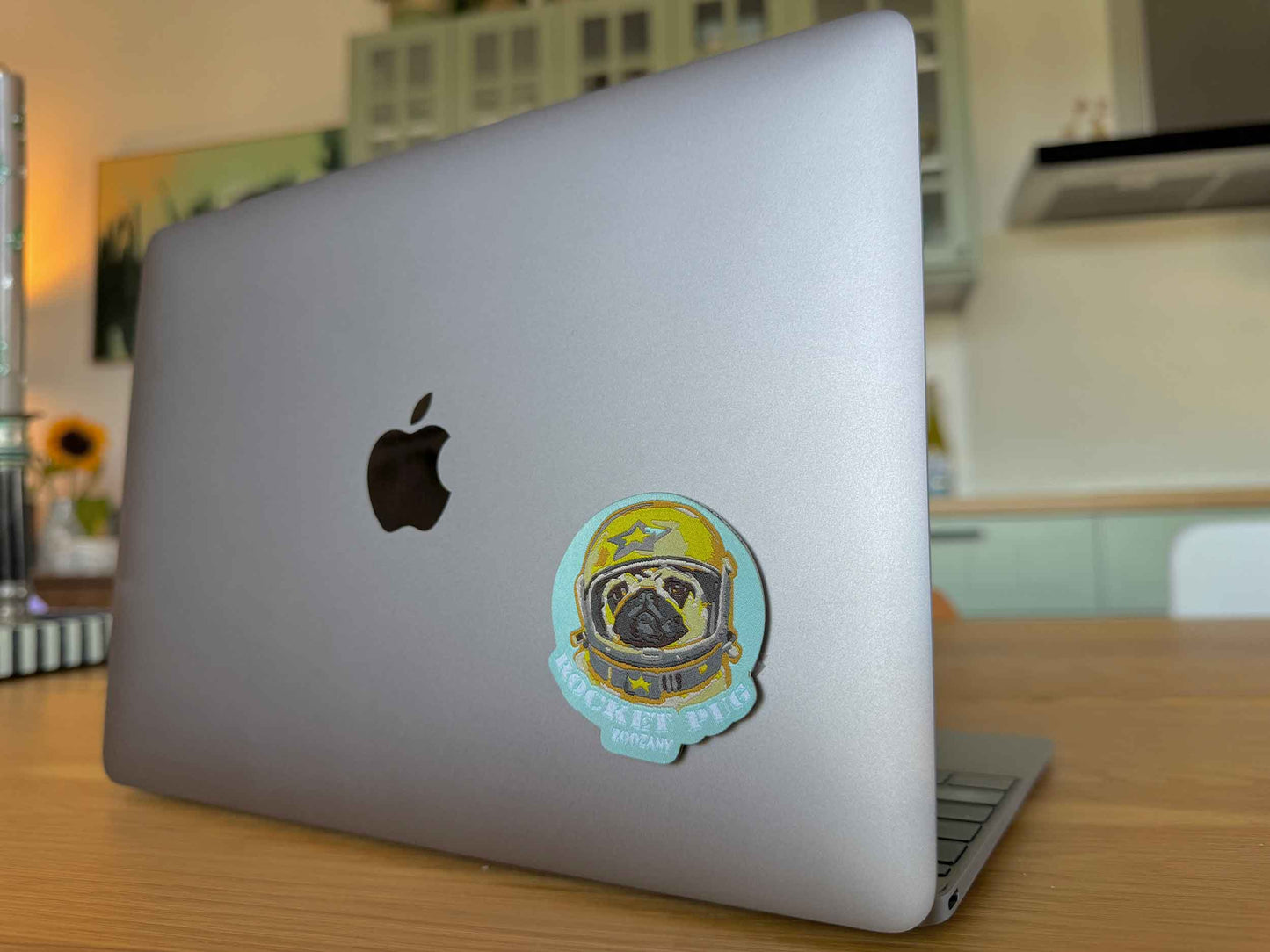 Gewebter Rocket Mops Sticker auf einem silbernen Laptop hinzugefügt, der eine süße Verzierung auf dem Gerät darstellt.