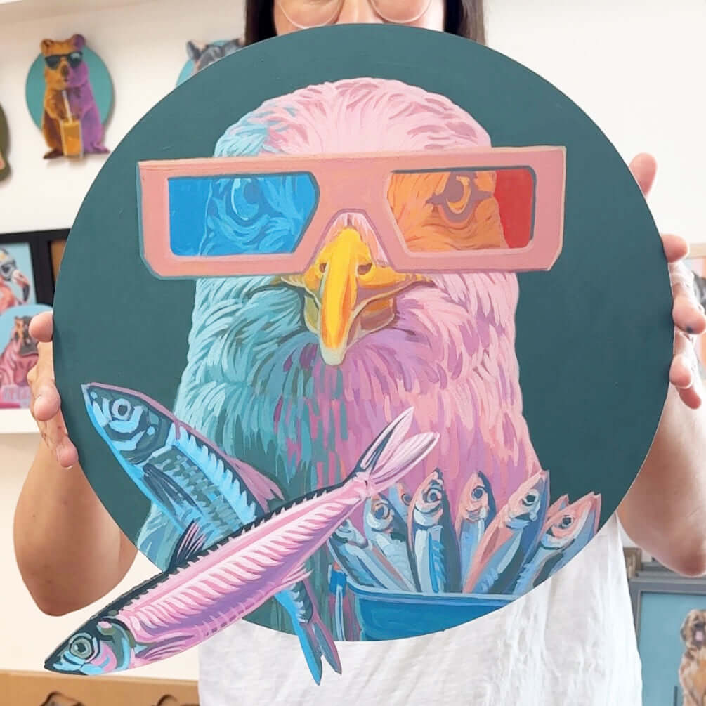 Person hält rundes sign painting mit Adler in 3D-Brille und bunten Fischen, 37 x 37 cm, im Hintergrund weitere Kunstwerke