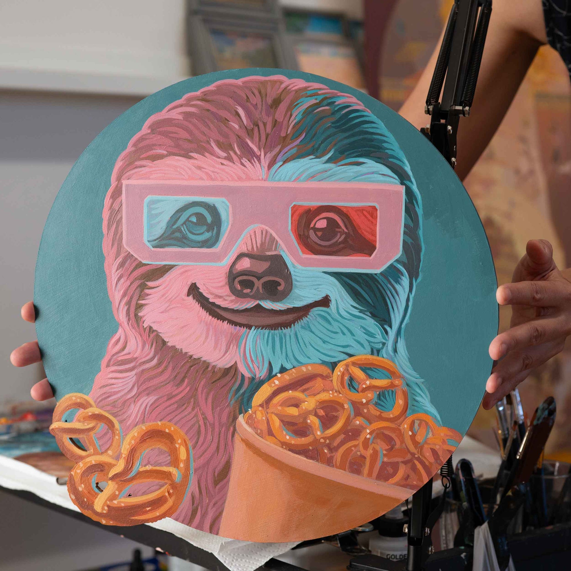 Eine handgemalte 3D Brezel Schild mit Retro-Design, zeigt einen lächelnden Sloth mit 3D-Brille und Brezeln im Vordergrund.