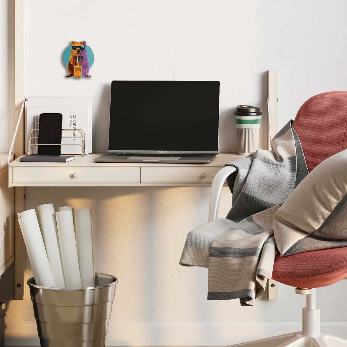 Moderner Arbeitsplatz mit Laptop, Kaffeetasse und dekorativem Quoka-Schilderdruck für humorvolles Flair im Homeoffice