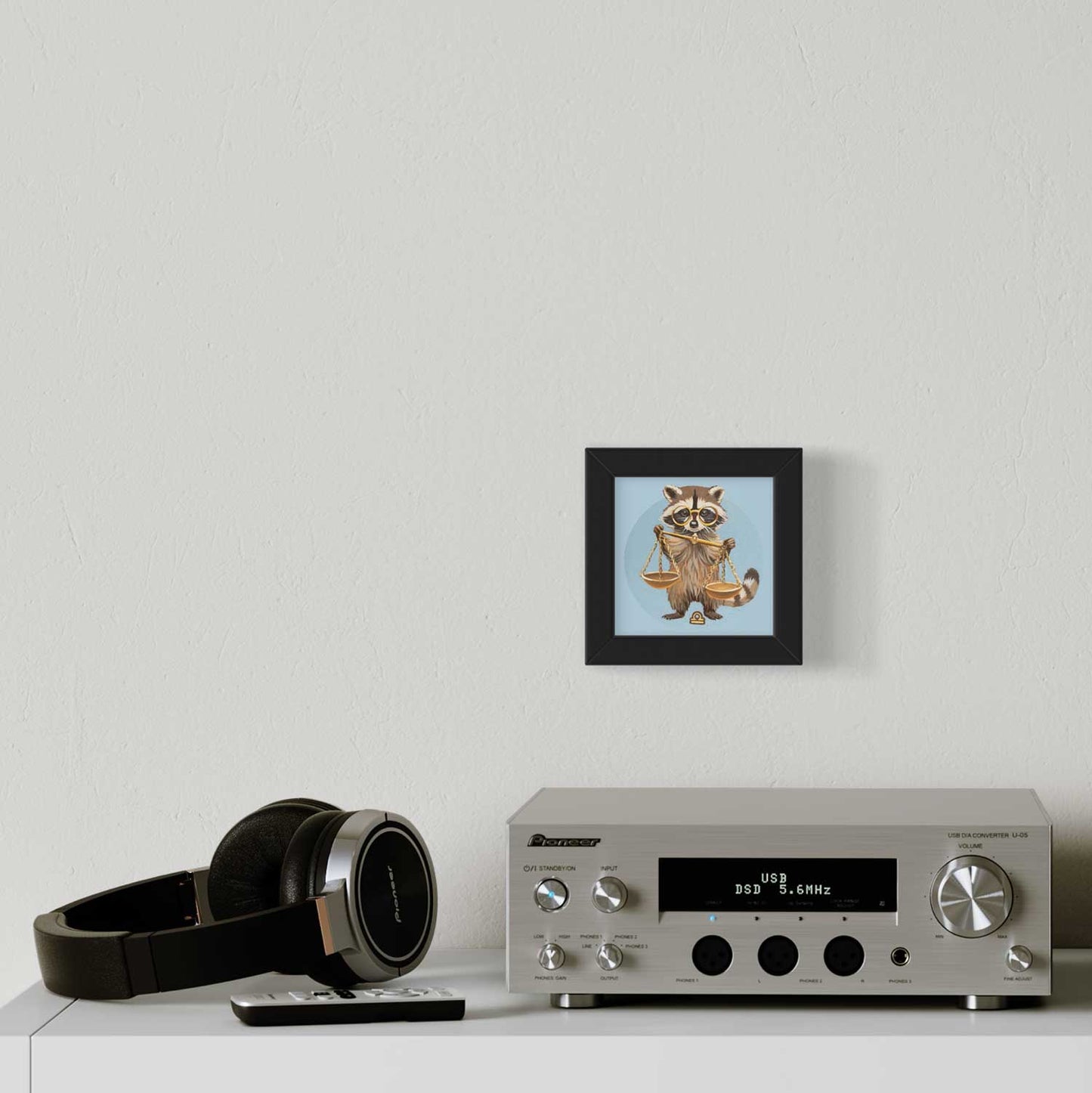 Cute raccoon Fine Art Print, framed, showcasing Libra zodiac symbol, stylishly placed beside a modern stereo and headphones.