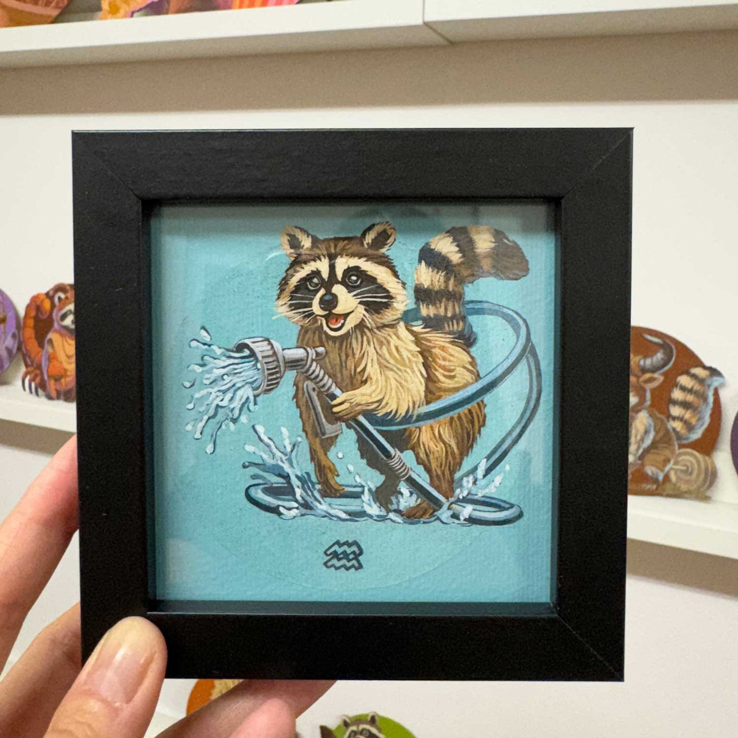 Cute raccoon art print in black frame, 10x10 cm, perfect for brightening up spaces, zodiac theme for Aquarius.